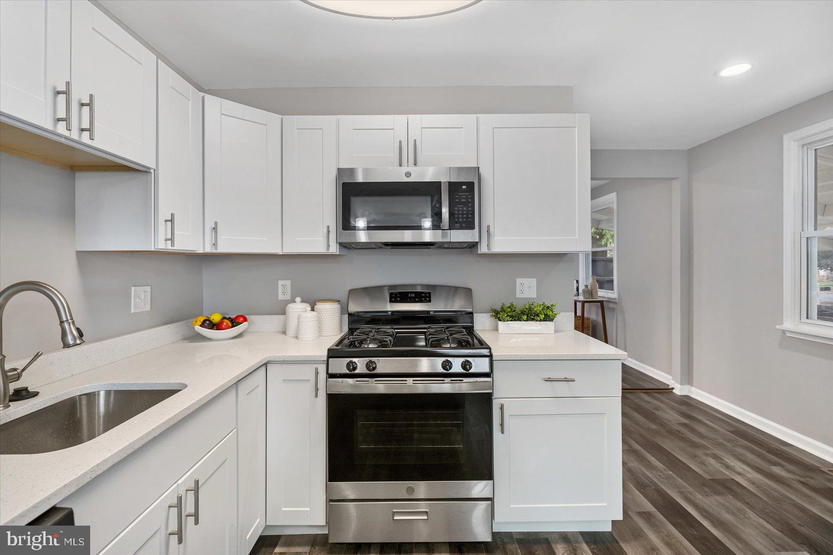 8217 Bullneck Road Baltimore, MD 21222 - Photo 14 of 41 a kitchen with stainless steel appliances granite countertop a stove a microwave and a sink