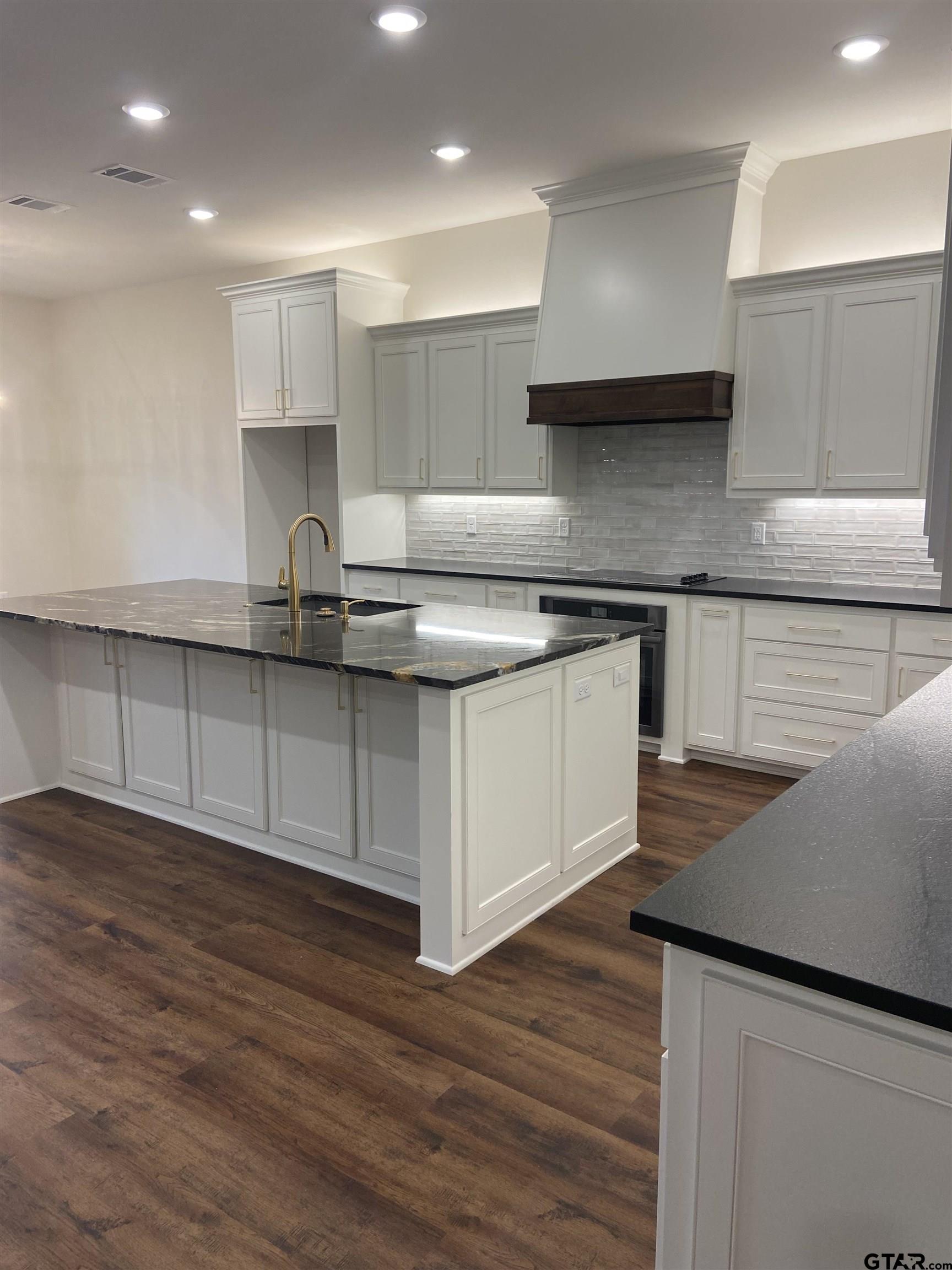 18690 Windjammer Place Flint, TX 75762 - Photo 16 of 47 a kitchen with stainless steel appliances granite countertop a sink stove and wooden floor