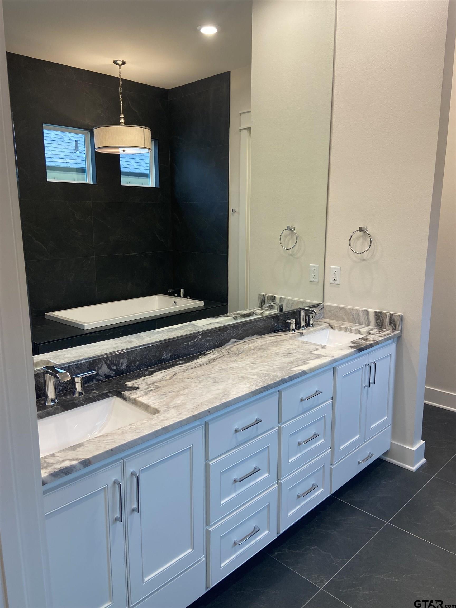 18690 Windjammer Place Flint, TX 75762 - Photo 33 of 47 a bathroom with a sink a large mirror and a