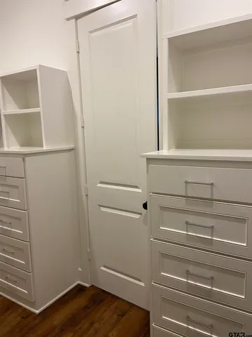 a view of walk in closet with empty racks