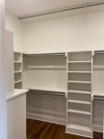 a view of walk in closet with empty racks