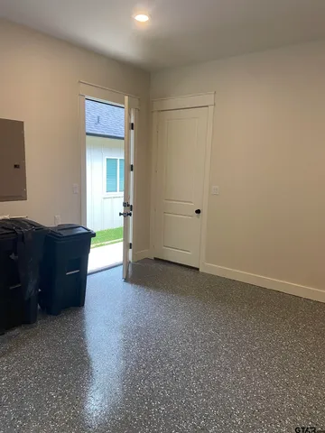 an empty room with a mirror and a dresser