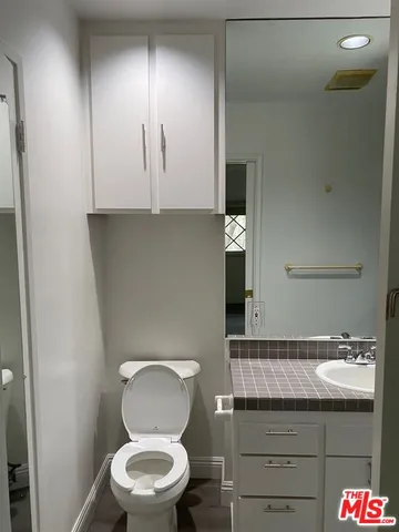 a bathroom with a toilet a sink and mirror