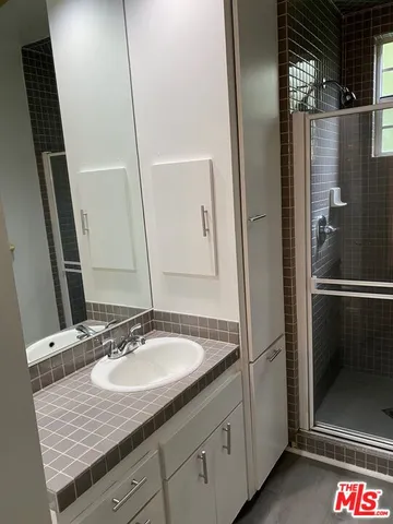 a bathroom with a granite countertop sink and a mirror