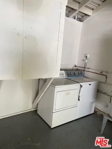 a utility room with cabinets washer and dryer