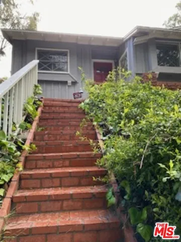 a front view of a house with plants