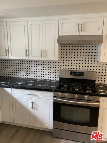 a stove top oven sitting inside of a kitchen
