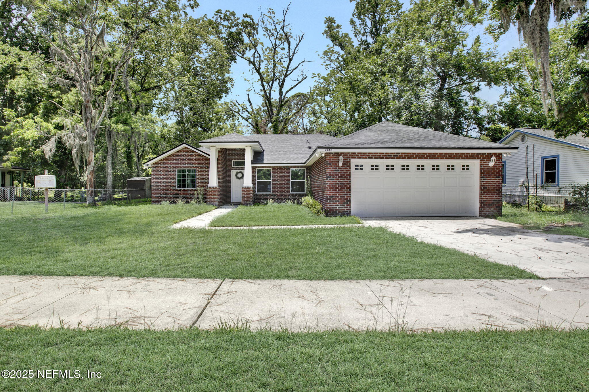 a front view of a house with a garden and yard