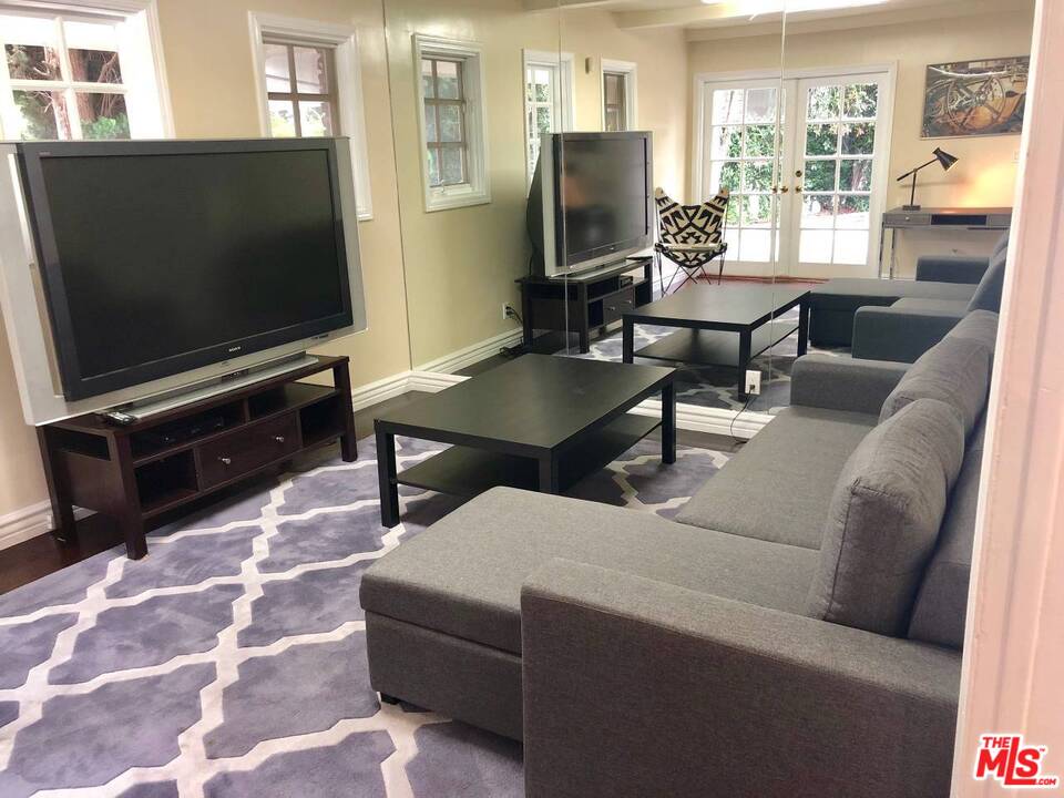 9601 Heather Road Beverly Hills, CA 90210 - Photo 10 of 17 a living room with furniture and a flat screen tv