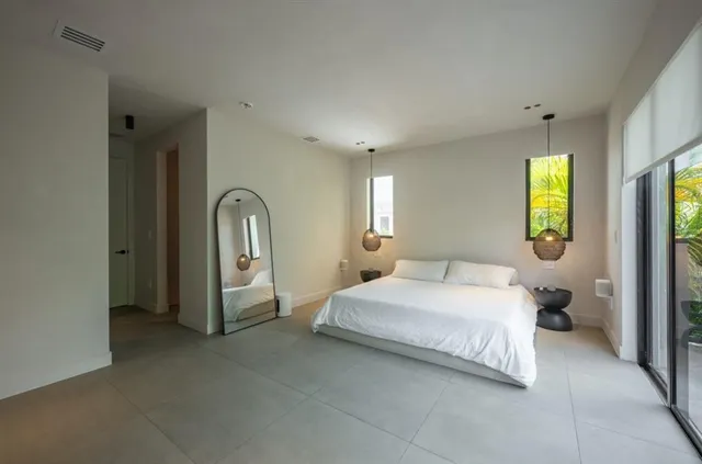 a bedroom with a bed and a large mirror