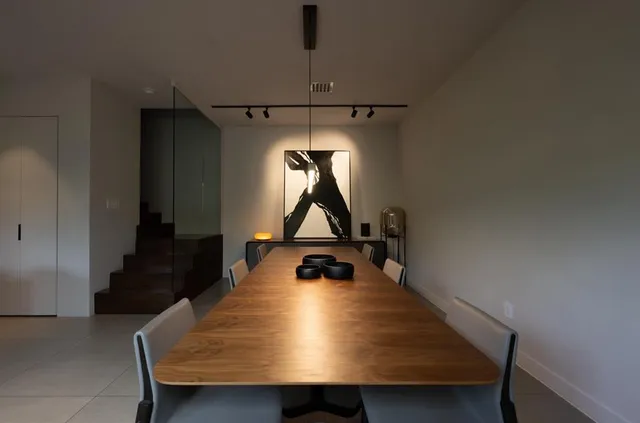 a room with table chairs and a potted plant