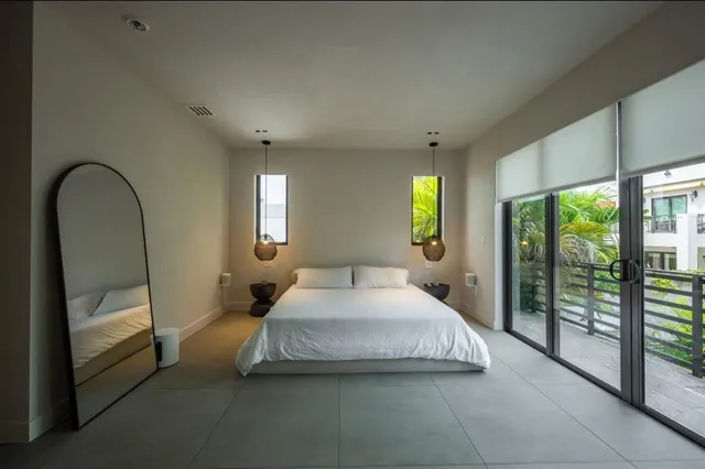 a bed sitting in a spacious bedroom next to a window