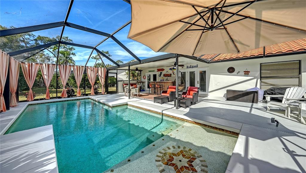 5968 Rachele Drive Sarasota, FL 34243 - Photo 41 of 55 a view of a patio with a table and chairs under an umbrella