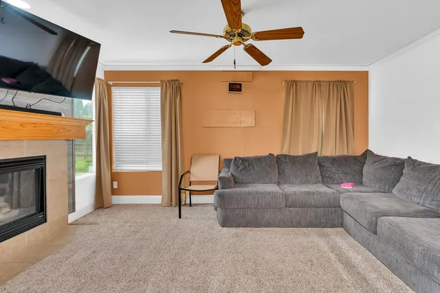 a living room with furniture a flat screen tv and a window