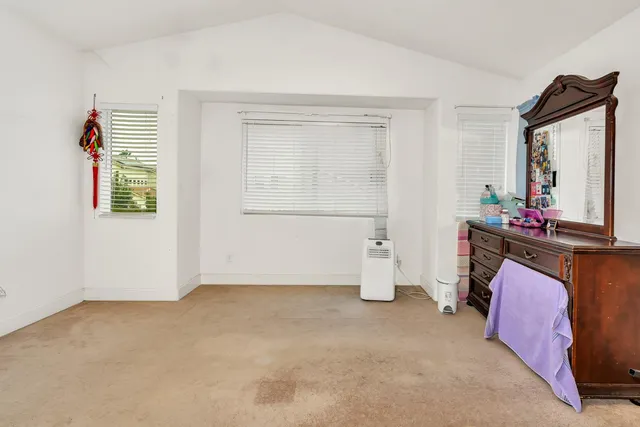 a spacious bedroom with a bed and a chandelier