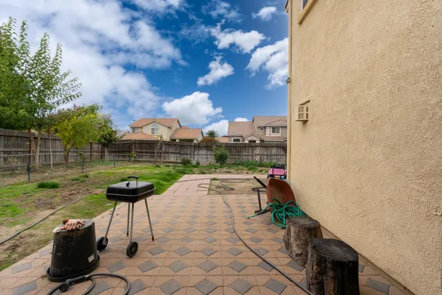 a view of house with backyard and furniture