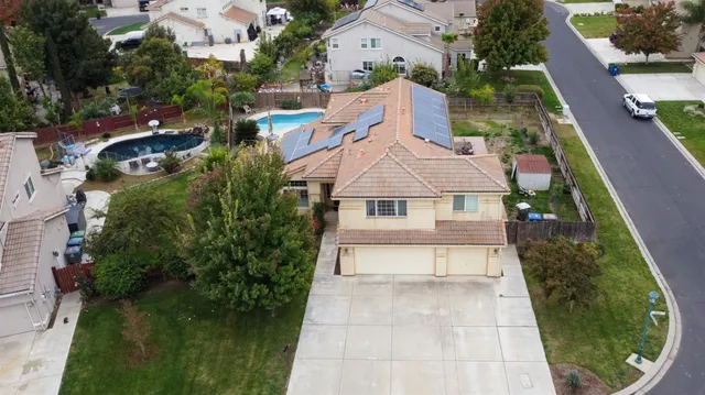 an aerial view of a house with a yard and outdoor seating