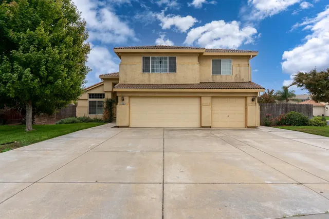 a front view of a house with a garden and garage