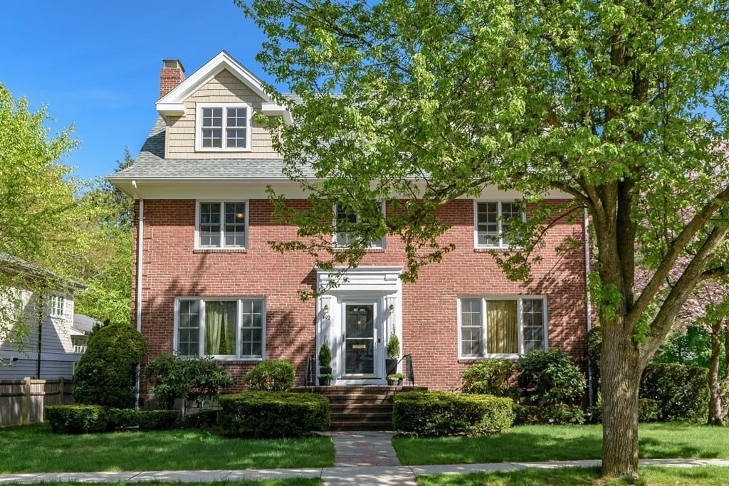a front view of a house with a yard and trees