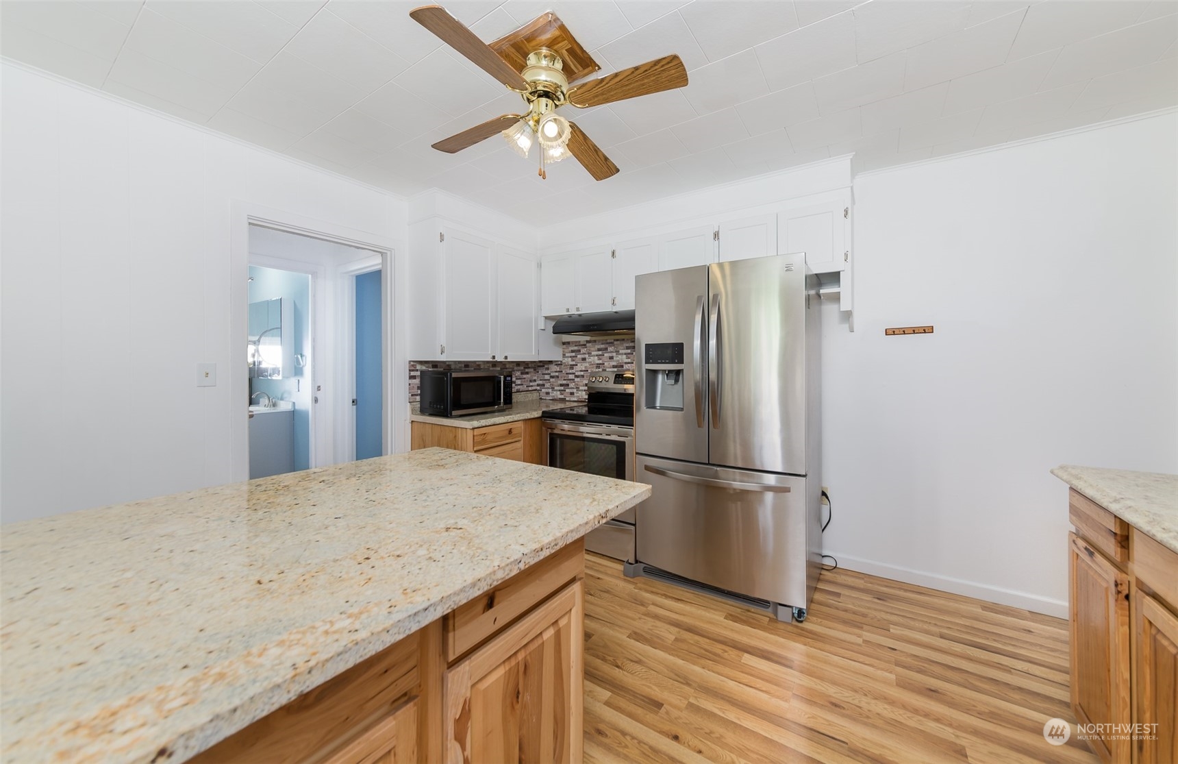6930 East Cady Road Everett, WA 98203 - Photo 7 of 22 a kitchen with granite countertop a refrigerator a sink and white cabinets