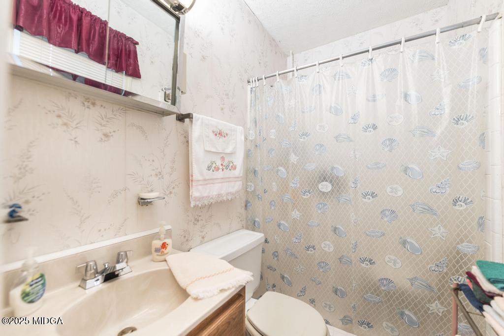 4112 West Hickory Court Macon, GA 31210 - Photo 8 of 12 a bathroom with a sink toilet and shower