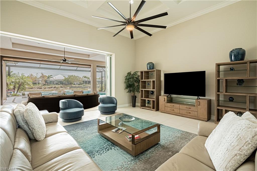 6262 Lightbourn Way Naples, FL 34113 - Photo 11 of 49 a living room with furniture a large window and a flat screen tv