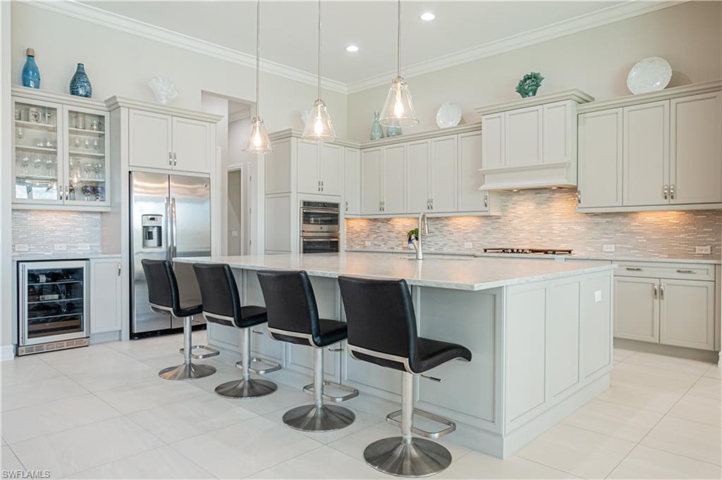 6262 Lightbourn Way Naples, FL 34113 - Photo 15 of 49 a kitchen with stainless steel appliances kitchen island granite countertop a stove a sink a dining table and chairs