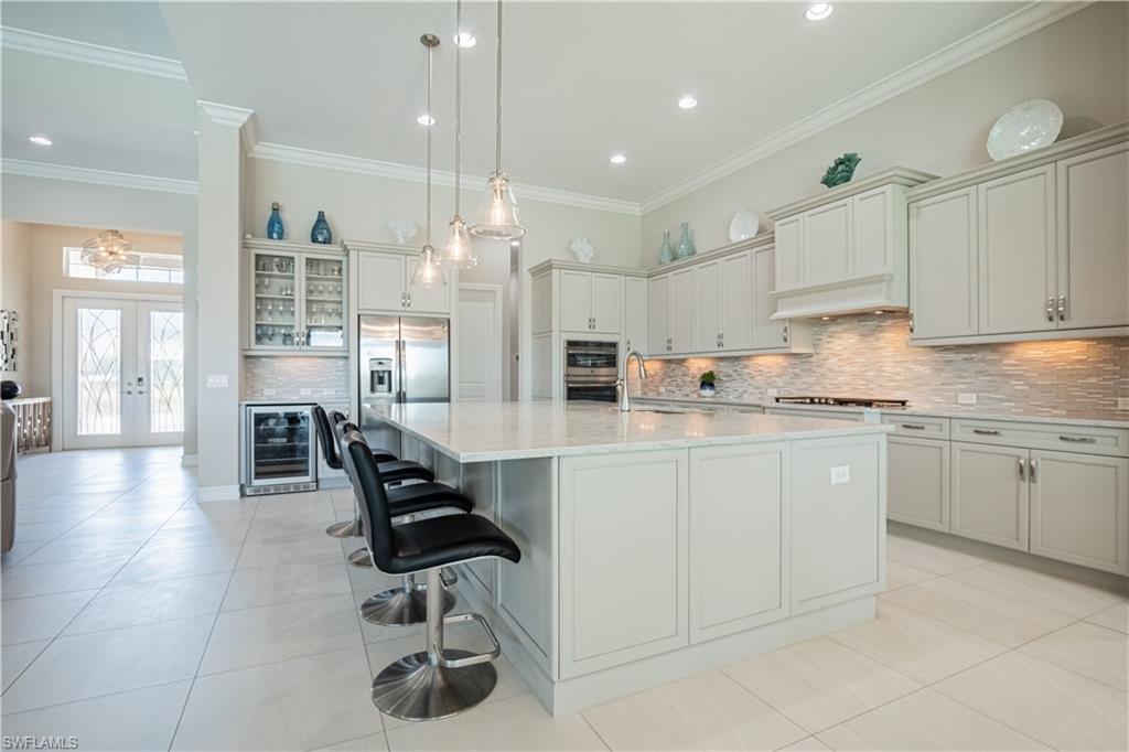 6262 Lightbourn Way Naples, FL 34113 - Photo 16 of 49 a kitchen with cabinets and chairs