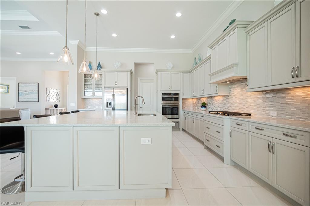 6262 Lightbourn Way Naples, FL 34113 - Photo 17 of 49 a kitchen with kitchen island granite countertop lots of white stainless steel appliances cabinets and a sink