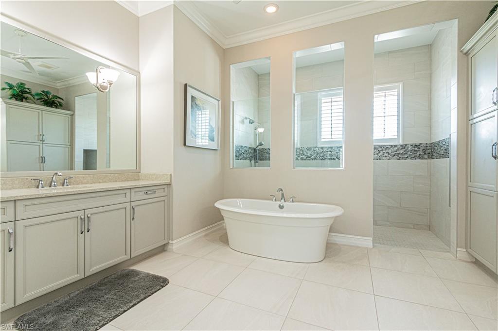 6262 Lightbourn Way Naples, FL 34113 - Photo 26 of 49 a spacious bathroom with a bathtub sink mirror and