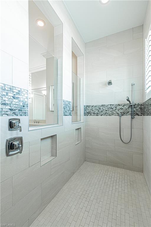 6262 Lightbourn Way Naples, FL 34113 - Photo 28 of 49 a bathroom with a granite countertop sink a mirror and a shower