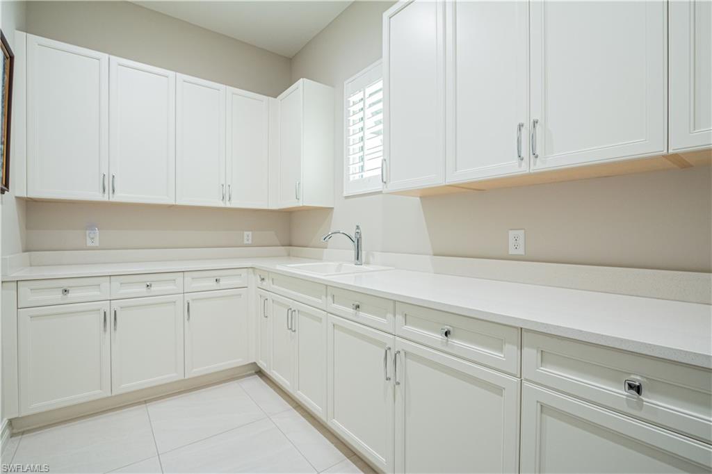 6262 Lightbourn Way Naples, FL 34113 - Photo 38 of 49 a kitchen with white cabinets and white appliances