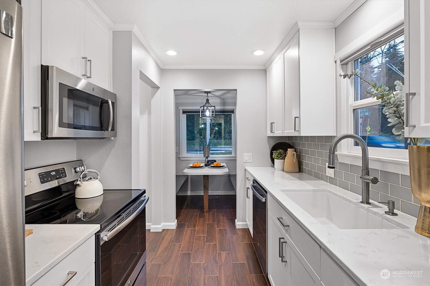 24008 Meridian Avenue South Bothell, WA 98021 - Photo 7 of 31 a kitchen with a sink dishwasher stove and microwave with wooden floor