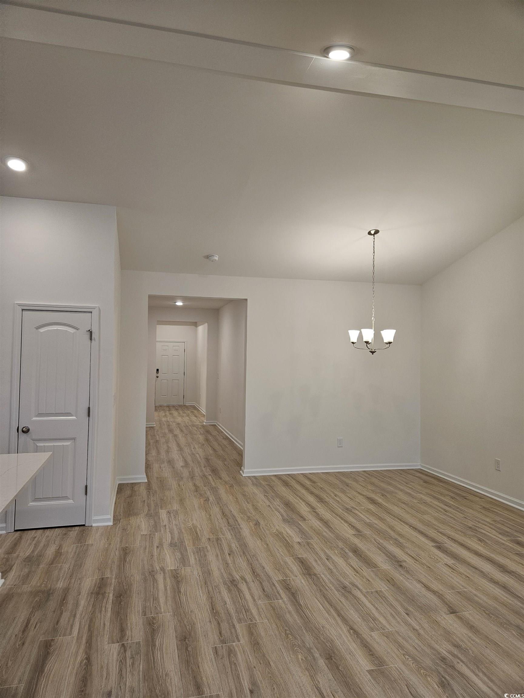 371 Kapalua Loop Little River, SC 29566 - Photo 20 of 37 Empty room with light wood finished floors, recessed lighting, and a chandelier