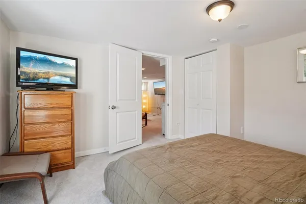 a bedroom with furniture window and flat screen tv