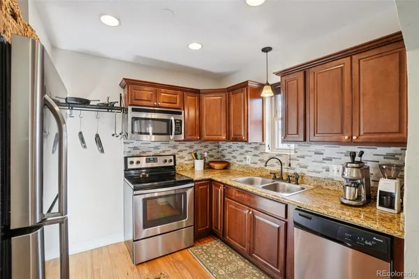 a kitchen with stainless steel appliances granite countertop a refrigerator stove and oven