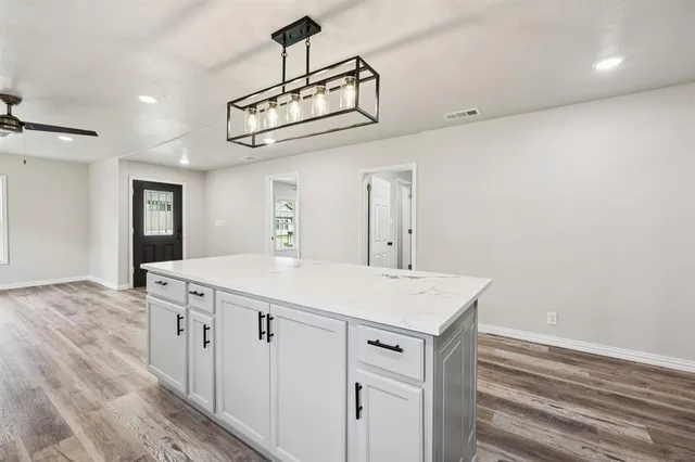 a view of a kitchen counter space a stove and wooden floor
