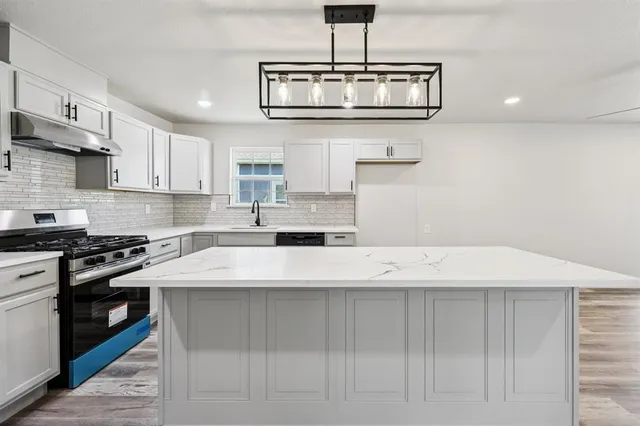 a kitchen with stainless steel appliances a sink and a stove