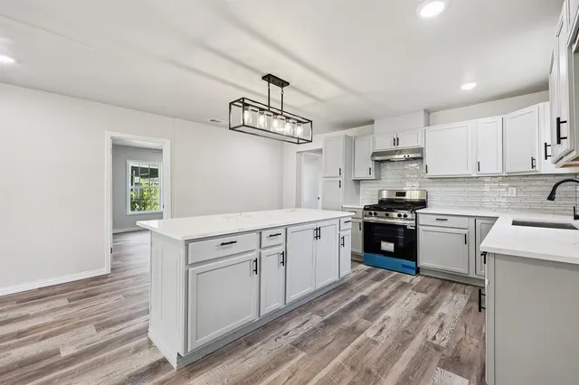 a kitchen with white cabinets and appliances
