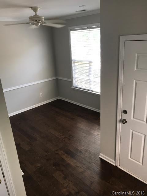 14925 Scothurst Lane Charlotte, NC 28277 - Photo 6 of 9 an empty room with wooden floor cabinet and windows