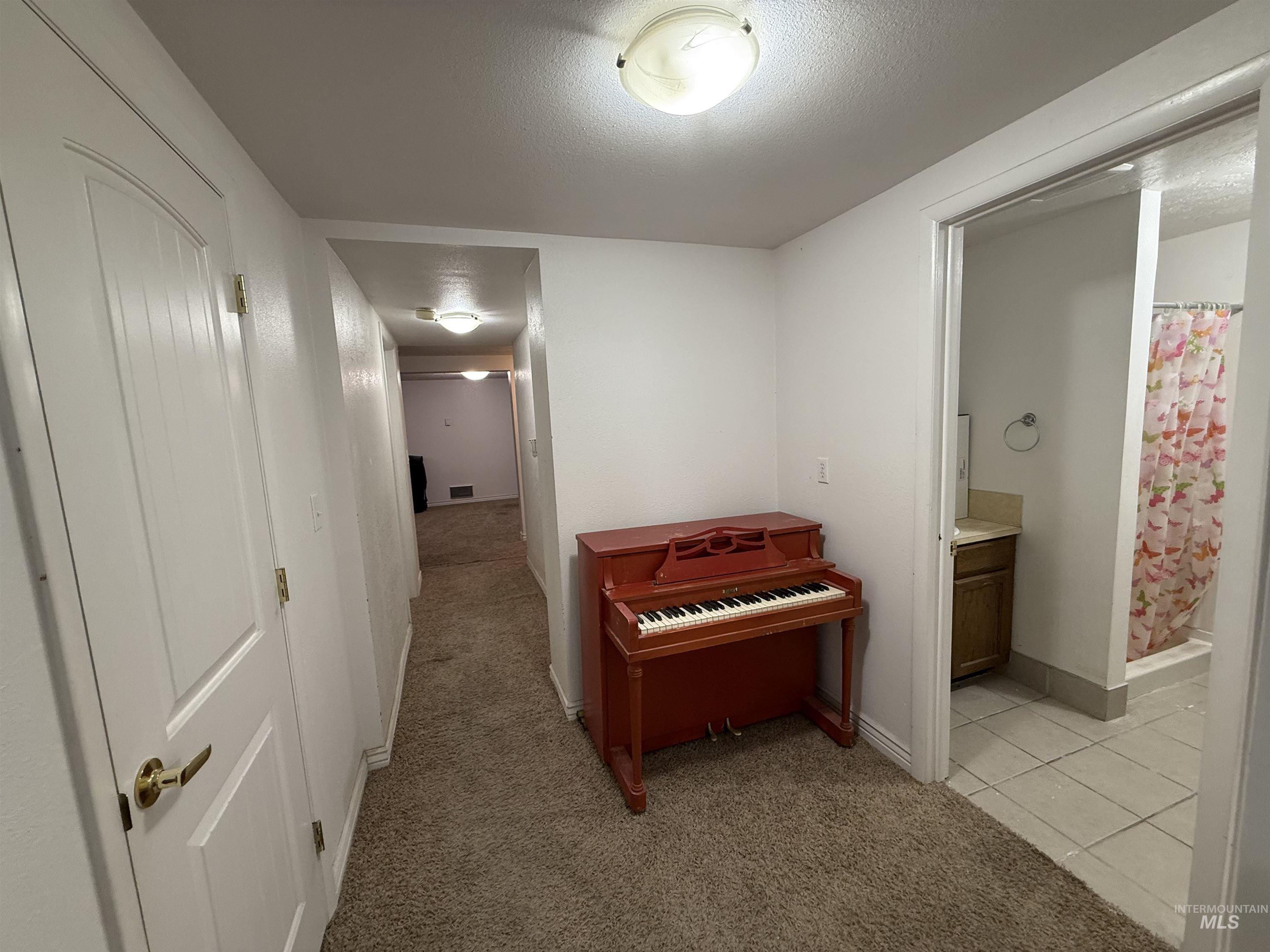 4926 Easy Street Chubbuck, ID 83202 - Photo 18 of 29 Hallway with light colored carpet and a textured ceiling