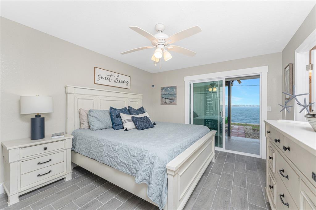 5041 North Beach Road, Unit 3A AND 3B Englewood, FL 34223 - Photo 16 of 52 a bedroom with a large bed and a chandelier