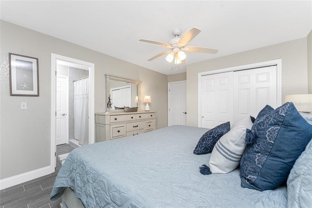 5041 North Beach Road, Unit 3A AND 3B Englewood, FL 34223 - Photo 18 of 52 a spacious bedroom with a bed and a chandelier