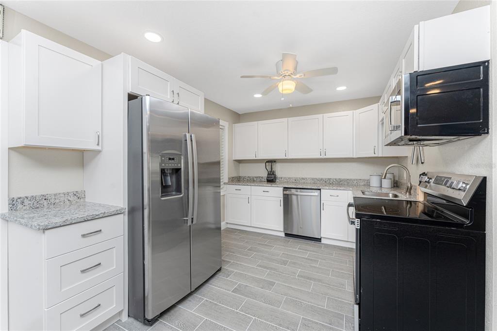 5041 North Beach Road, Unit 3A AND 3B Englewood, FL 34223 - Photo 4 of 52 a kitchen with a sink stainless steel appliances and cabinets