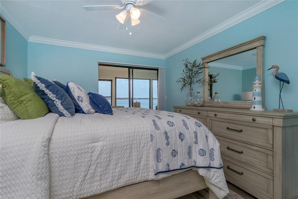 5041 North Beach Road, Unit 3A AND 3B Englewood, FL 34223 - Photo 43 of 52 a bedroom with a large bed and a chandelier
