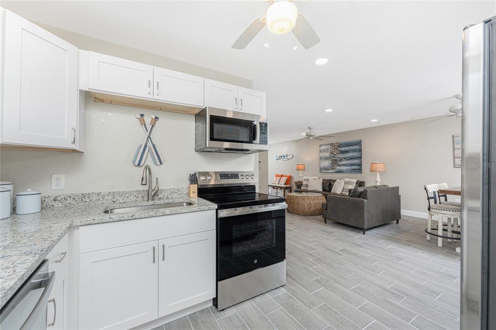5041 North Beach Road, Unit 3A AND 3B Englewood, FL 34223 - Photo 7 of 52 a kitchen with a stove a sink and a refrigerator