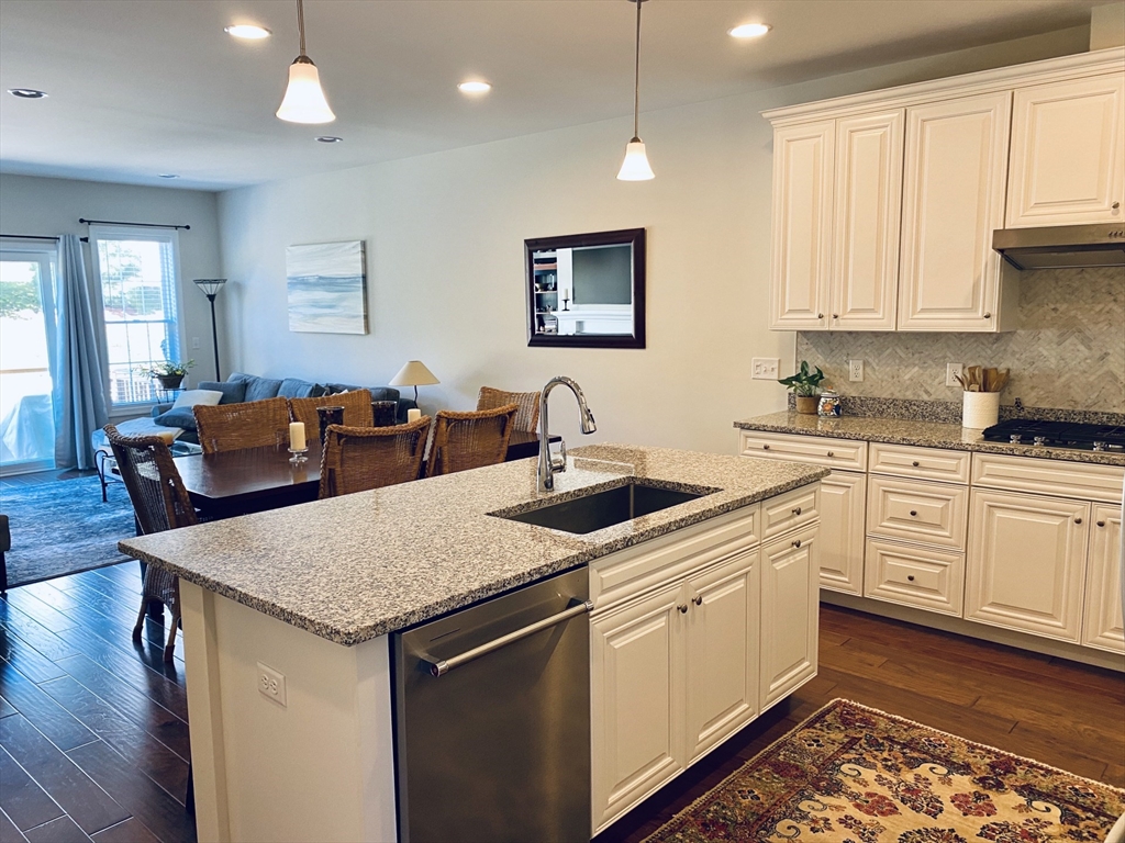 41 Shannon Way, Unit 41 Upton, MA 01568 - Photo 11 of 36 a open kitchen with stainless steel appliances granite countertop a sink dishwasher and white cabinets with wooden floor