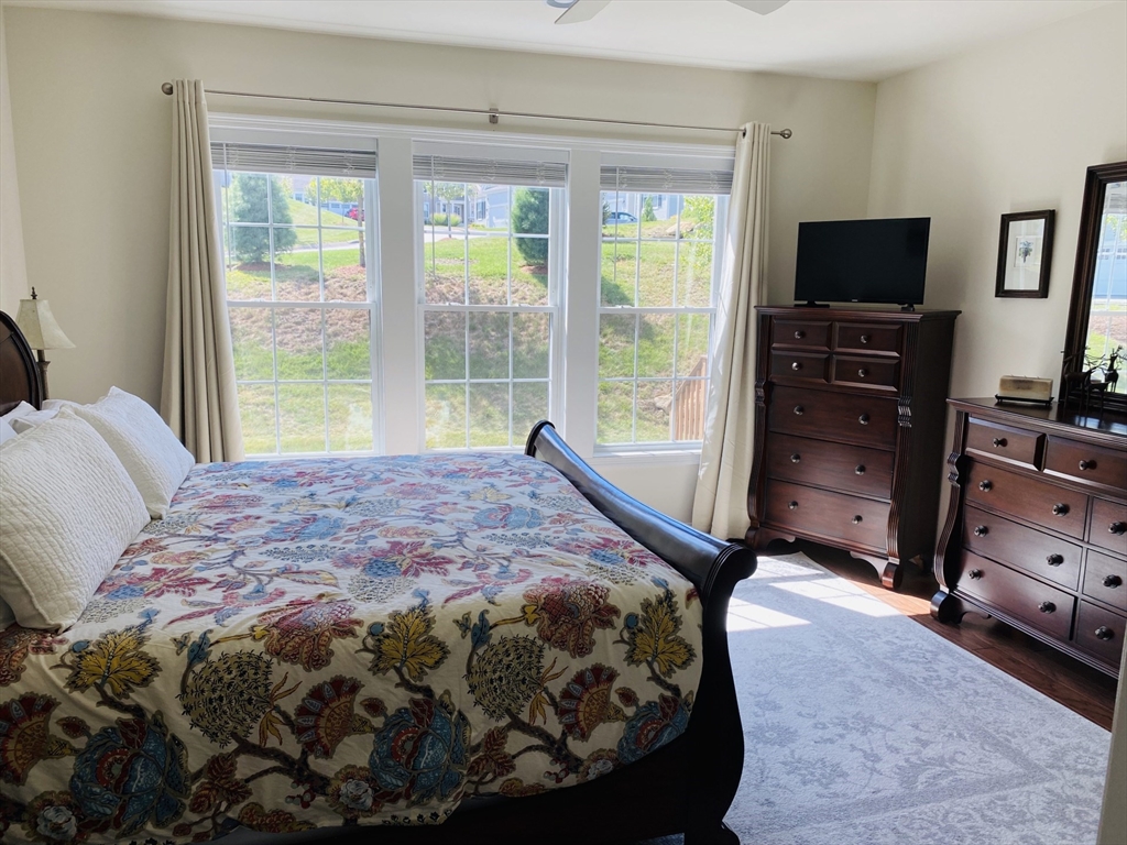 41 Shannon Way, Unit 41 Upton, MA 01568 - Photo 20 of 36 a bedroom with a bed and a flat tv screen