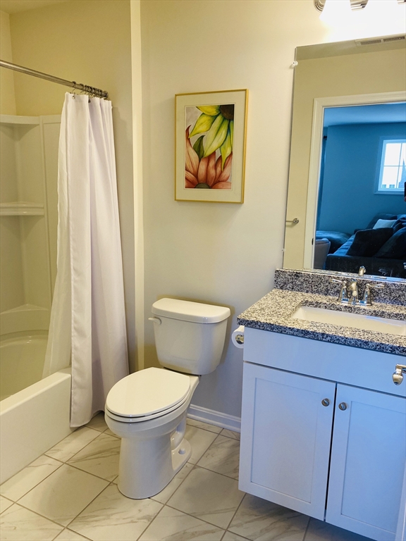 41 Shannon Way, Unit 41 Upton, MA 01568 - Photo 26 of 36 a bathroom with a granite countertop toilet a sink and a mirror