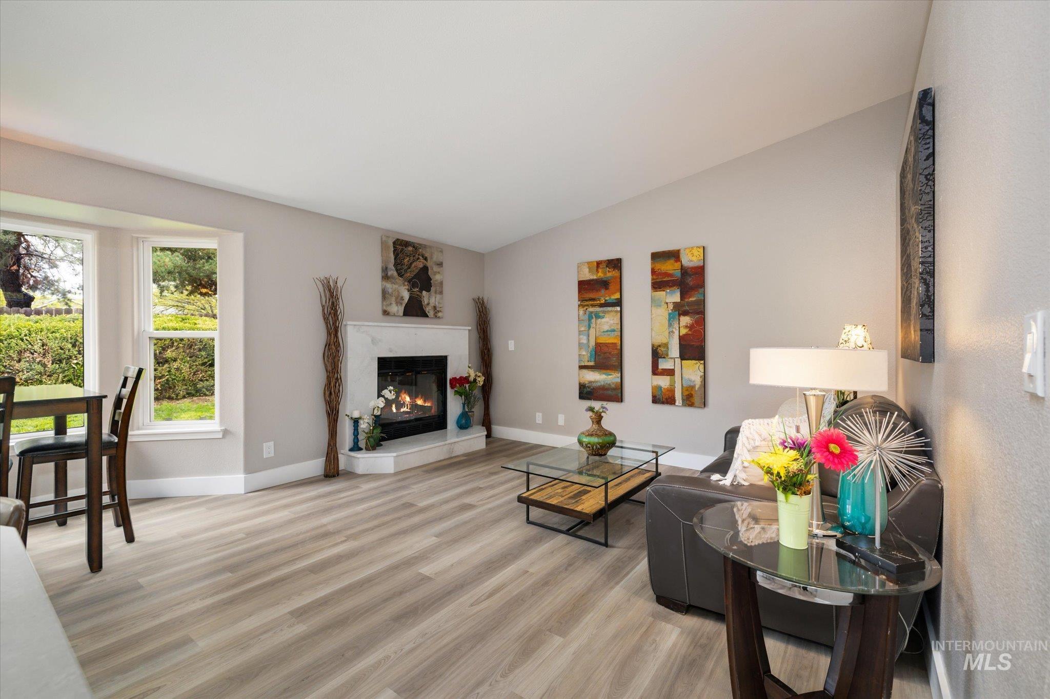 2250 North Amethyst Avenue Meridian, ID 83646 - Photo 24 of 50 Living room featuring light wood-style flooring, a glass covered fireplace, and lofted ceiling